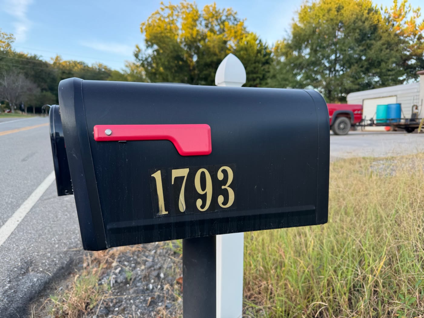 Black mailbox marked 1793 with a red flag, across the street from State Collision